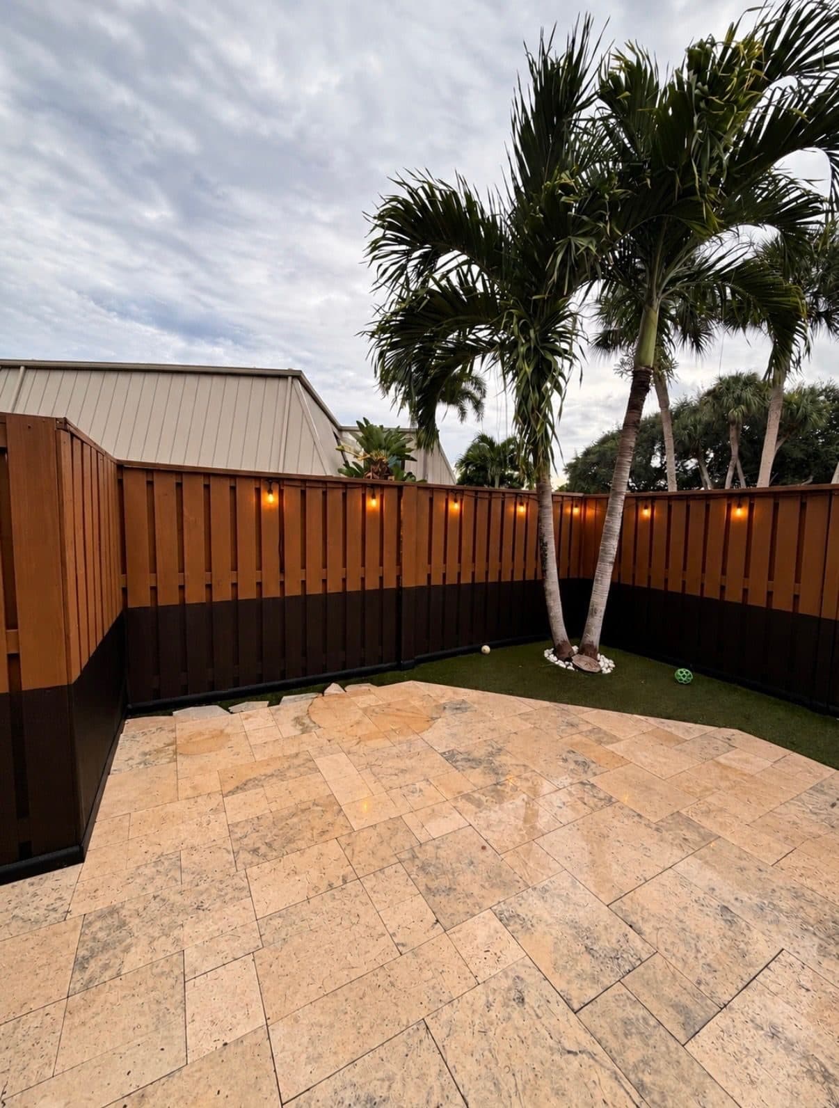 A South Florida backyard with a cane toad barrier installed along the base of the fence
